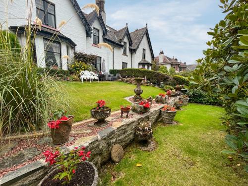a yard with potted plants and a house at Tigh N Eilean in Aberfeldy