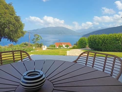 ein Tisch mit Sonnenschirm darauf mit Blick auf das Wasser in der Unterkunft Nerea in Ayia Evfimia