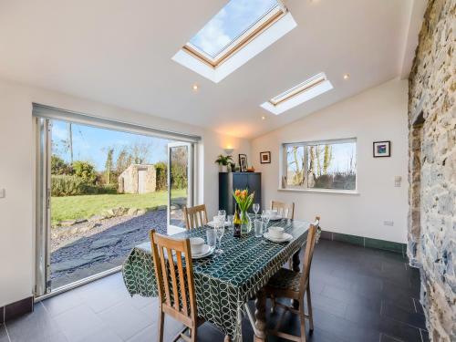 Un comedor con mesa y sillas en The Granary - Uk48740, en Gaerwen