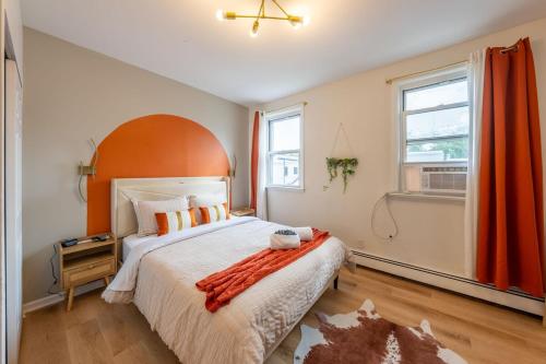 a bedroom with a large bed with an orange headboard at Stylish 2 BD Apt-18 mins from NYC-Steps away Bus stop, Restaurants, Groceries in Jersey City