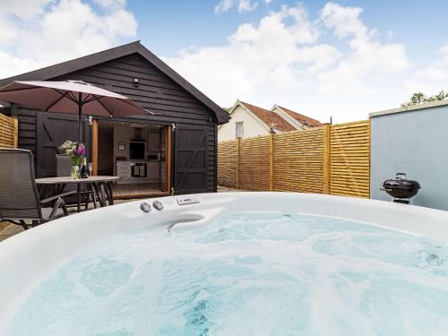 a hot tub in the backyard of a house at Wisteria Lodge - Ukc5804 in Shelfanger