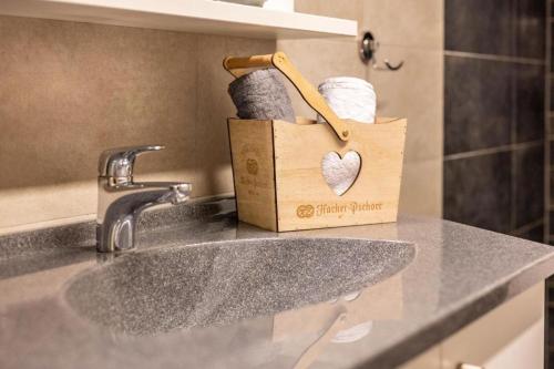 a bathroom counter with a sink and a paper towel holder at Alpenappart in Cadipietra