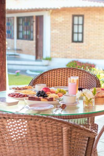 a table with a breakfast of breakfast foods on it at Pousada Praia das Tartarugas in Barra de Tabatinga