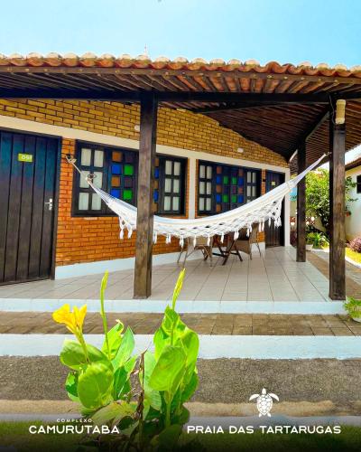 a building with a hammock in front of it at Pousada Praia das Tartarugas in Barra de Tabatinga