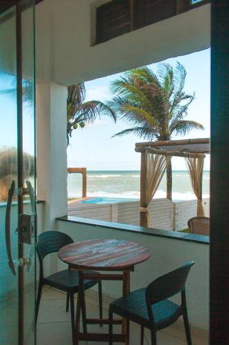 a table and chairs in a room with a view of the beach at Pousada Praia das Tartarugas in Barra de Tabatinga
