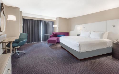 a hotel room with a bed and a desk and chair at Crowne Plaza Cleveland at Playhouse Square by IHG in Cleveland