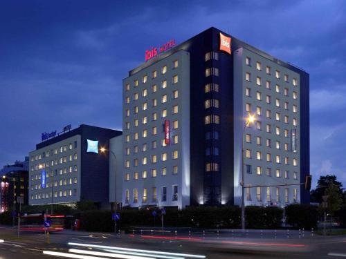 a tall building with a sign on top of it at ibis Warszawa West Station in Warsaw