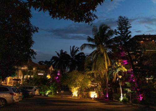 a city street at night with palm trees and lights at Sweet Garden Hotel Kumasi in Trofwi