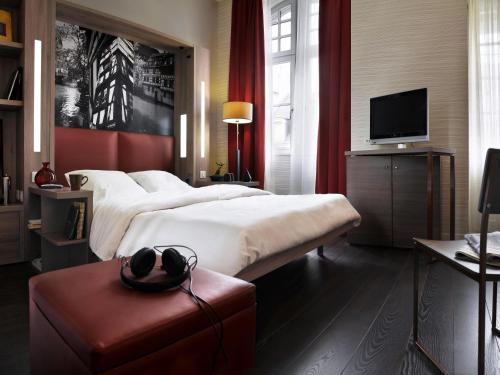 a hotel room with two beds and a television at Aparthotel Adagio Strasbourg Place Kleber in Strasbourg