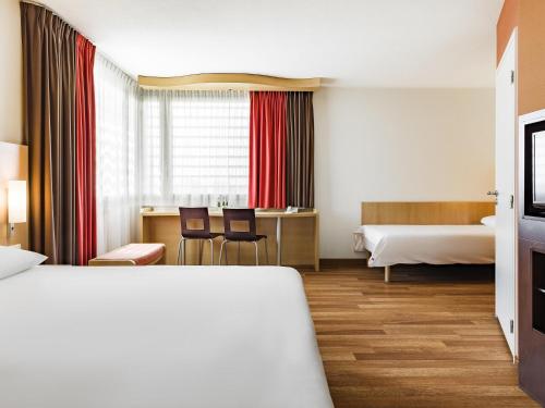 a hotel room with a bed and a desk at ibis Warszawa West Station in Warsaw