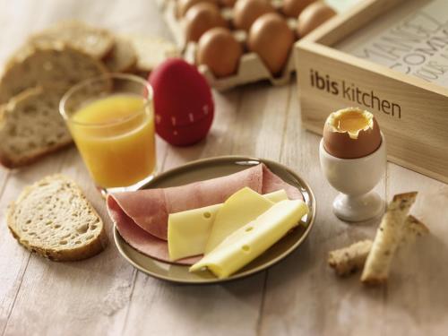 a table with a plate of cheese and eggs and bread at ibis Warszawa West Station in Warsaw
