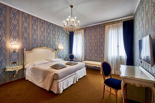 a bedroom with a bed and a chandelier at Hotel Gardena in Venice