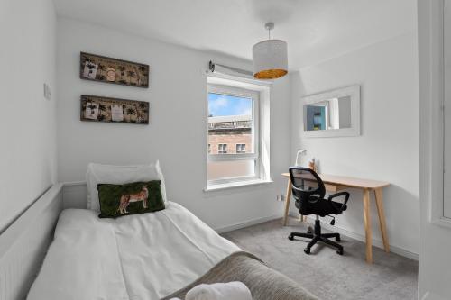 a bedroom with a bed and a desk and a window at Holyrood Duplex 3-Bedroom Apartment in Edinburgh