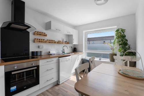 a kitchen with a dining table and a large window at Holyrood Duplex 3-Bedroom Apartment in Edinburgh