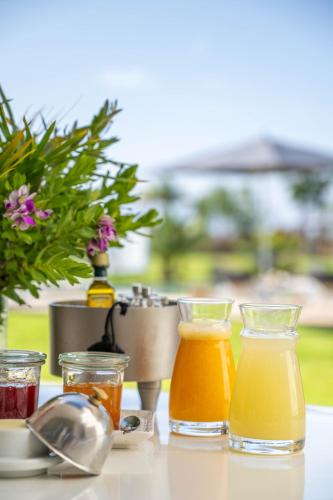 a table with three glasses of orange juice and a juicer at Dar Syada Boutique Hotel Marrakech in Marrakech