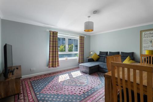 a living room with a couch and a window at Holyrood Duplex 3-Bedroom Apartment in Edinburgh