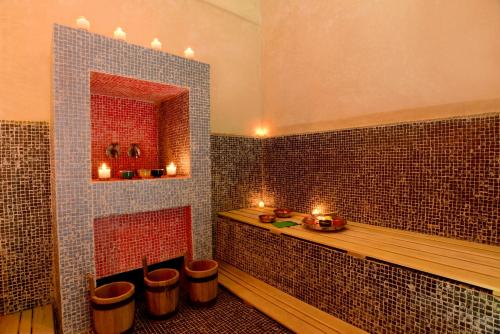 a bathroom with a tub with candles in it at Dar Syada Boutique Hotel Marrakech in Marrakech