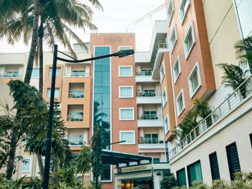 an apartment building with palm trees and a street light at Grand Mercure Bangalore - An Accor Brand in Bengaluru