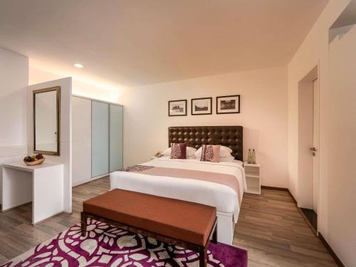 a bedroom with a large bed and a table at Grand Mercure Bangalore - An Accor Brand in Bengaluru