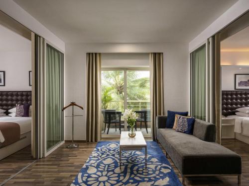a hotel room with a bed and a couch at Grand Mercure Bangalore - An Accor Brand in Bengaluru