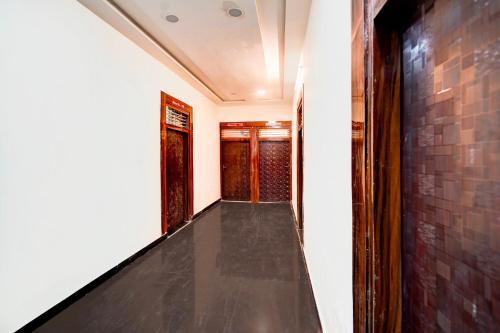 a hallway with a black floor and a brick wall at Hotel O Parth Hotel And Restaurant in Fīrozābād