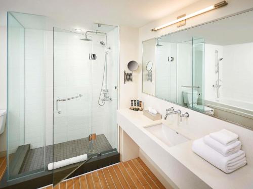 a bathroom with a glass shower and a sink at Novotel Toronto Vaughan Centre in Vaughan