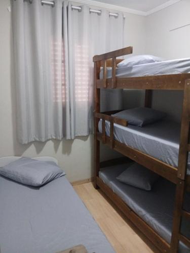 a bedroom with two bunk beds and a window at Apartamento 222 Pé na Praça 1 vaga Garagem 8 hóspedes in Poços de Caldas