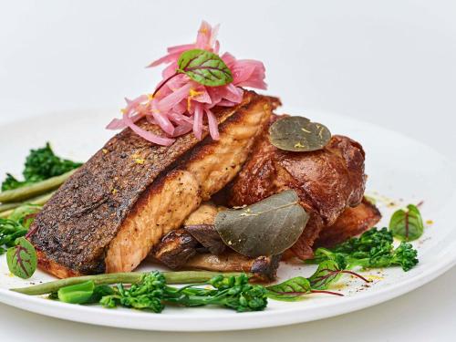 a white plate of food with meat and vegetables at Novotel Toronto Vaughan Centre in Vaughan