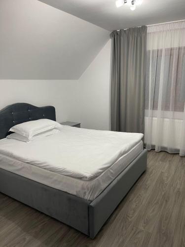 a bed in a bedroom with a white wall at Vila Cantacuzino in Buşteni