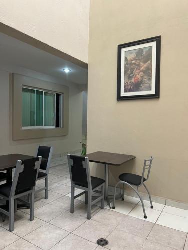 a dining room with tables and chairs and a picture on the wall at Hotel Bamboo Sauces Morelia in Morelia