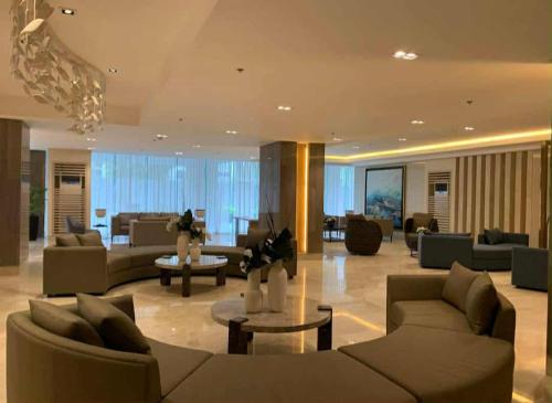 a large living room with couches and tables at SkyShore in Manila