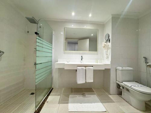 a bathroom with a toilet and a sink and a shower at Casa Mare Resort - ex, Royal Tulip Beach Resort in Port Ghalib