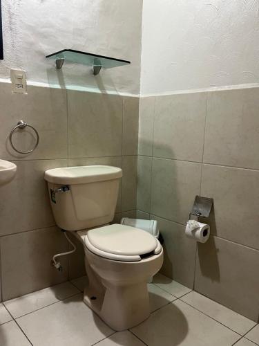 a bathroom with a toilet and a toilet paper dispenser at Hotel Bamboo Sauces Morelia in Morelia