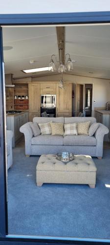 a living room with two couches and a kitchen at Platinum villa in Whitstable