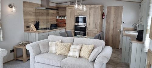 a living room with a couch and a kitchen at Platinum villa in Whitstable