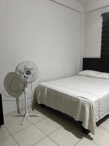 a bedroom with a bed and a table and a fan at Hotel Bamboo Sauces Morelia in Morelia
