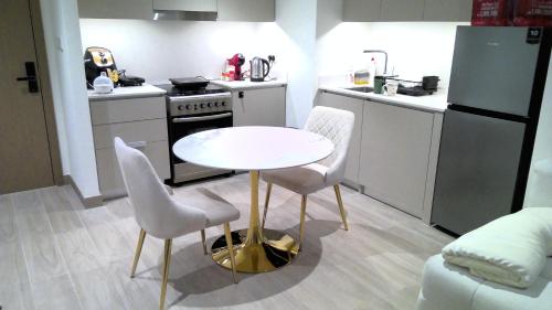 a small kitchen with a white table and chairs at Apartment In Creek Beach in Dubai