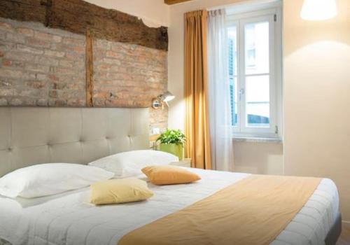 a bedroom with a large bed with two pillows at La Corte Fiorita Como in Como