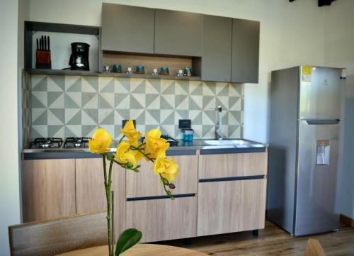 a kitchen with yellow flowers in a vase on a table at Cabaña del lago con Jacuzzi in Rionegro
