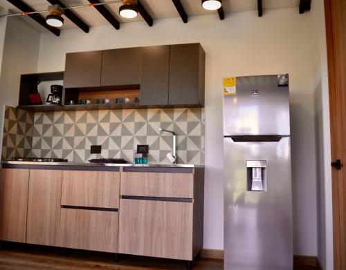 a kitchen with a stainless steel refrigerator at Cabaña del lago con Jacuzzi in Rionegro