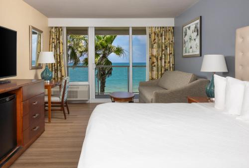 a hotel room with a bed and a view of the ocean at Ocean Breeze Inn Vero Beach in Vero Beach