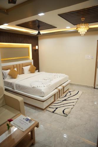 a bedroom with a bed and a couch and a table at Hotel Laxmi Premium in Jāmb