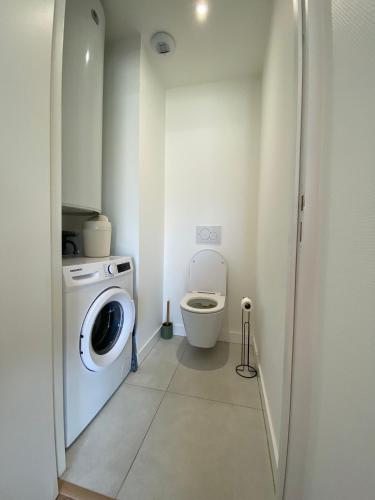 a bathroom with a washing machine and a toilet at L'Escale - Charming Seaside house by Harbor in Cancale