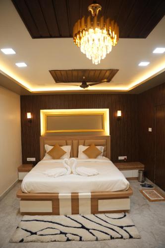 a bedroom with a large bed with a chandelier at Hotel Laxmi Premium in Jāmb