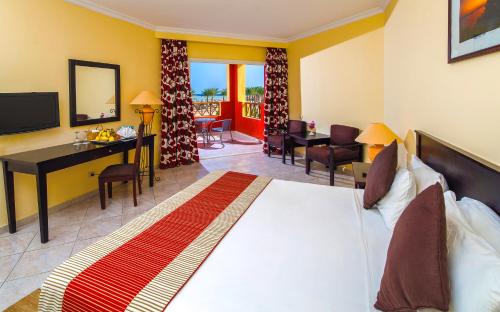 a hotel room with a large bed and a desk at Casa Mare Resort - ex, Royal Tulip Beach Resort in Port Ghalib
