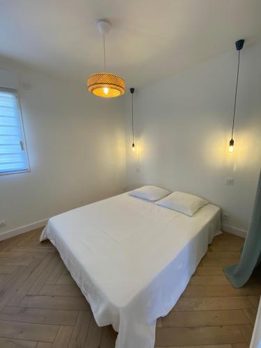 a white bedroom with a white bed and a light at L'Escale - Charming Seaside house by Harbor in Cancale