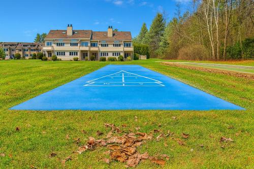 a large house with a blue driveway in the grass at The Ponds at Foxhollow in Lenox