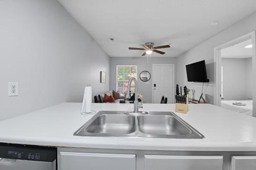 a kitchen with a sink and a ceiling fan at Cozy Contemporary Stay I Pool & Gym I Free Parking in Spring Lake