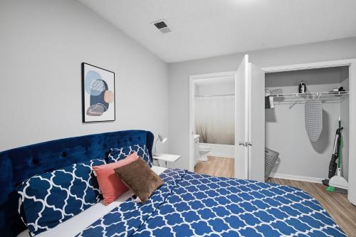 a bedroom with a blue bed and a bathroom at Bright Modern 1br Retreat I Fitness Center in Spring Lake
