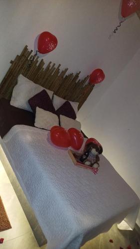 a bedroom with a bed with red balloons on it at Balcones del Rio Tobia in Nimaima